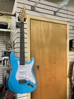 Fojill Strat Style Electric Guitar In Blue With Amp Open. Price: $349.00.